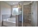 Modern tiled bathroom showcasing a separate shower with glass door and a garden tub under a window at 419 Murphy Ave, Canton, GA 30114