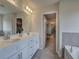 Modern bathroom featuring double sinks, walk-in closet, and bathtub at 419 Murphy Ave, Canton, GA 30114