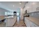 Modern kitchen flows to living room with stainless appliances, grey backsplash, and island seating at 419 Murphy Ave, Canton, GA 30114