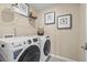 Bright laundry room featuring a washer, dryer, and stylish wall decor at 216 Wilder Ridge Way, Lawrenceville, GA 30044