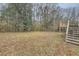 Large backyard with a wooden deck and surrounding trees at 2374 Rolling Acres Sw Dr, Conyers, GA 30094