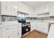 Modern kitchen featuring white cabinets, gray backsplash and stainless steel appliances at 680 Branch Valley Ct, Roswell, GA 30076