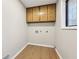 Bright laundry room with wood-look floors and ample storage at 680 Branch Valley Ct, Roswell, GA 30076