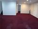 Finished basement featuring maroon carpeting, multiple entry points and ample space at 100 Meadow Lake Dr, Carrollton, GA 30116