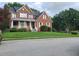 Two story brick home with a front porch and landscaped yard at 100 Meadow Lake Dr, Carrollton, GA 30116