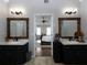 Double vanity bathroom with dark cabinets and mirrors, and views into bedroom at 107 Vestry Walk, Douglasville, GA 30134