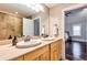 Bathroom with double sinks, light wood cabinets, and view of bedroom at 107 Howard Ne St, Atlanta, GA 30317