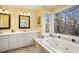 Main bathroom with double vanity, soaking tub, and large window at 1883 Acuba Ln, Atlanta, GA 30345