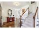 Elegant entryway with hardwood floors, staircase, and red console table at 632 Graymont Dr, Grayson, GA 30017