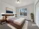 Virtually staged main bedroom with wood bed frame and large window at 3430 Laurel Springs Cv, Villa Rica, GA 30180