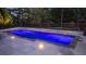 Rectangular pool with blue lighting, surrounded by a large patio and landscaping at 109 Slate Dr, Buford, GA 30518