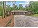 Brick ranch home with mature landscaping, two-car garage, and circular driveway surrounded by shade trees at 263 Weldon Rd, Palmetto, GA 30268