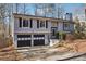 Split-level home featuring two-car garage, neutral siding, and a chimney, blending suburban charm with functional design at 190 Hembree Forest Cir, Roswell, GA 30076