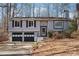 Split-level home featuring two-car garage, neutral siding, and a chimney, blending suburban charm with functional design at 190 Hembree Forest Cir, Roswell, GA 30076