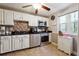 Well-equipped kitchen featuring white cabinets, black countertops, stainless steel appliances, and a decorative backsplash at 190 Hembree Forest Cir, Roswell, GA 30076