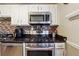 This kitchen features stainless steel appliances and dark granite countertops at 190 Hembree Forest Cir, Roswell, GA 30076
