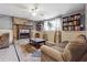 Cozy living room featuring a stone fireplace, ceiling fan, bookshelves, and comfortable seating at 190 Hembree Forest Cir, Roswell, GA 30076