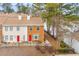 Two-story townhome with brick and siding exterior, red door, and carport at 207 Holcomb Ferry Rd, Roswell, GA 30076