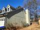 House side view, showcasing light green siding and a white chimney at 1129 Realm Ln, Lawrenceville, GA 30044