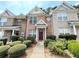 Brick townhouse with a burgundy door and manicured landscaping at 2025 Austin Park Cir, Decatur, GA 30032