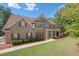 Two-story brick home with red shutters, landscaped yard, and a large front porch at 140 Lost Forest Dr, Mcdonough, GA 30252