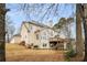 Exterior elevation showing a multi-story home with a backyard deck, set amidst mature trees at 2290 Spencers Way, Stone Mountain, GA 30087