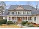 Inviting home with a covered porch, stone supports, double door entry, and lush landscaping in a serene setting at 2290 Spencers Way, Stone Mountain, GA 30087