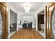 Elegant foyer with hardwood floors, chandelier, and a view into the living room with large windows at 2290 Spencers Way, Stone Mountain, GA 30087