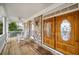 Covered front porch with stone accents, white columns, rocking chairs, and a double door entrance with glass accents at 2290 Spencers Way, Stone Mountain, GA 30087