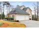 Three car garage with driveway, manicured lawn, and mature trees surrounding the property at 2290 Spencers Way, Stone Mountain, GA 30087