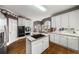 Well-lit kitchen featuring a center island cooktop, white cabinetry and hardwood flooring at 2290 Spencers Way, Stone Mountain, GA 30087