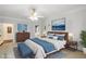 Well-lit main bedroom with a bed dressed in blue and white linens and artwork on the walls at 2290 Spencers Way, Stone Mountain, GA 30087