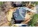 Aerial view showcases a home with a patio, surrounded by a lush lawn and mature trees at 1105 River Laurel Dr, Suwanee, GA 30024
