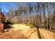 Sloped backyard with lush grass and a boundary of mature trees at 1105 River Laurel Dr, Suwanee, GA 30024