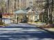 View of the gated entrance to the property surrounded by mature trees and lush landscaping at 1105 River Laurel Dr, Suwanee, GA 30024