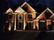 Stately brick home illuminated at night with manicured landscaping and architectural details at 1105 River Laurel Dr, Suwanee, GA 30024
