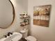 Powder room with a pedestal sink, a mirror, and decorative shelving and art at 1105 River Laurel Dr, Suwanee, GA 30024