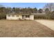 White ranch house with carport and mature trees at 24 Valerie Ln, Powder Springs, GA 30127
