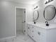 Bathroom featuring double sinks with modern fixtures, marble tile flooring, and a walk-in closet at 7015 Setters Way, Lithonia, GA 30038