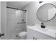 Bathroom with glass shower doors, modern vanity, and round mirror at 7015 Setters Way, Lithonia, GA 30038