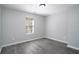 A simple bedroom featuring gray walls, wood flooring, and a bright window at 7015 Setters Way, Lithonia, GA 30038