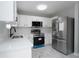 This is a modern kitchen featuring stainless steel appliances and white cabinetry at 7015 Setters Way, Lithonia, GA 30038