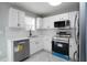 Bright kitchen with white cabinets, stainless steel appliances, and stylish backsplash at 7015 Setters Way, Lithonia, GA 30038
