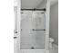 Shower featuring modern fixtures, a sliding door, and marble tile in the bathroom at 7015 Setters Way, Lithonia, GA 30038