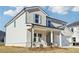 Two-story house with light brick and gray siding, a white two-car garage, and a front porch at 1569 High Falls Ln, Grayson, GA 30017