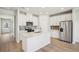 Open kitchen with island, white cabinets, and stainless steel appliances at 1569 High Falls Ln, Grayson, GA 30017