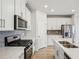 Modern kitchen with white cabinets and stainless steel appliances at 1569 High Falls Ln, Grayson, GA 30017