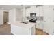 Modern kitchen with white cabinets and a large island at 1569 High Falls Ln, Grayson, GA 30017