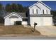 Two-story house with gray siding, a two-car garage, and a neatly landscaped lawn at 5332 Shirewick Dr, Lithonia, GA 30058
