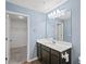 A full bathroom with a vanity with a white countertop and with an open walk-in closet at 2056 Wildflower Way, Conyers, GA 30012